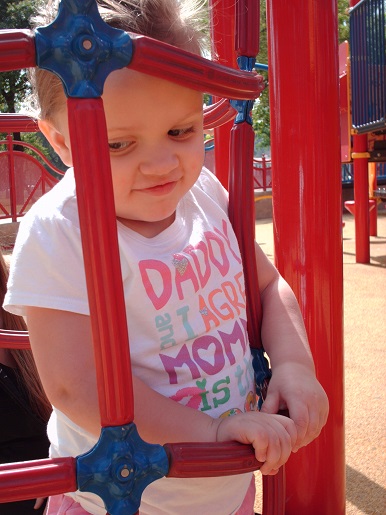 a little girl playing at park day